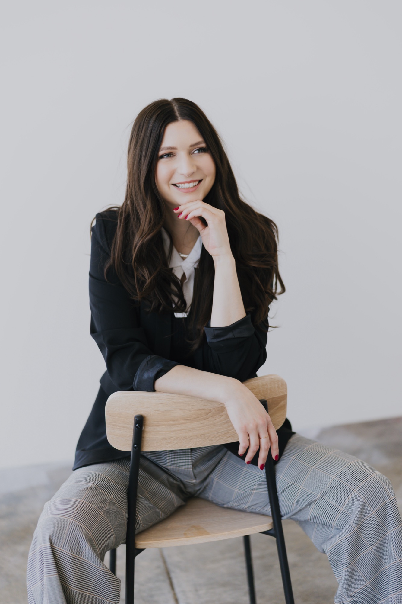 Shelby, the registered aesthetician and bridal makeup artist behind Glow Charm, seated and smiling