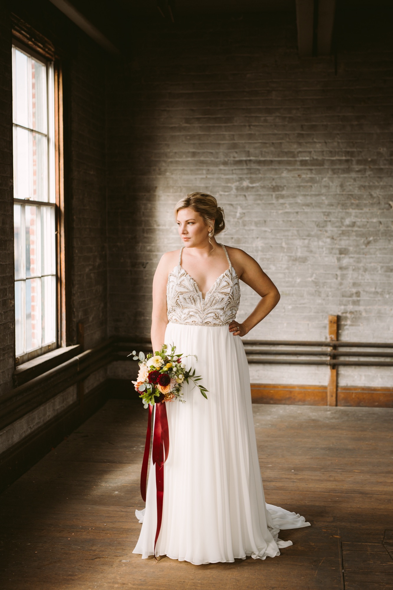 Bride in a beaded gown holding an autumn bouquet, soft romantic bridal makeup