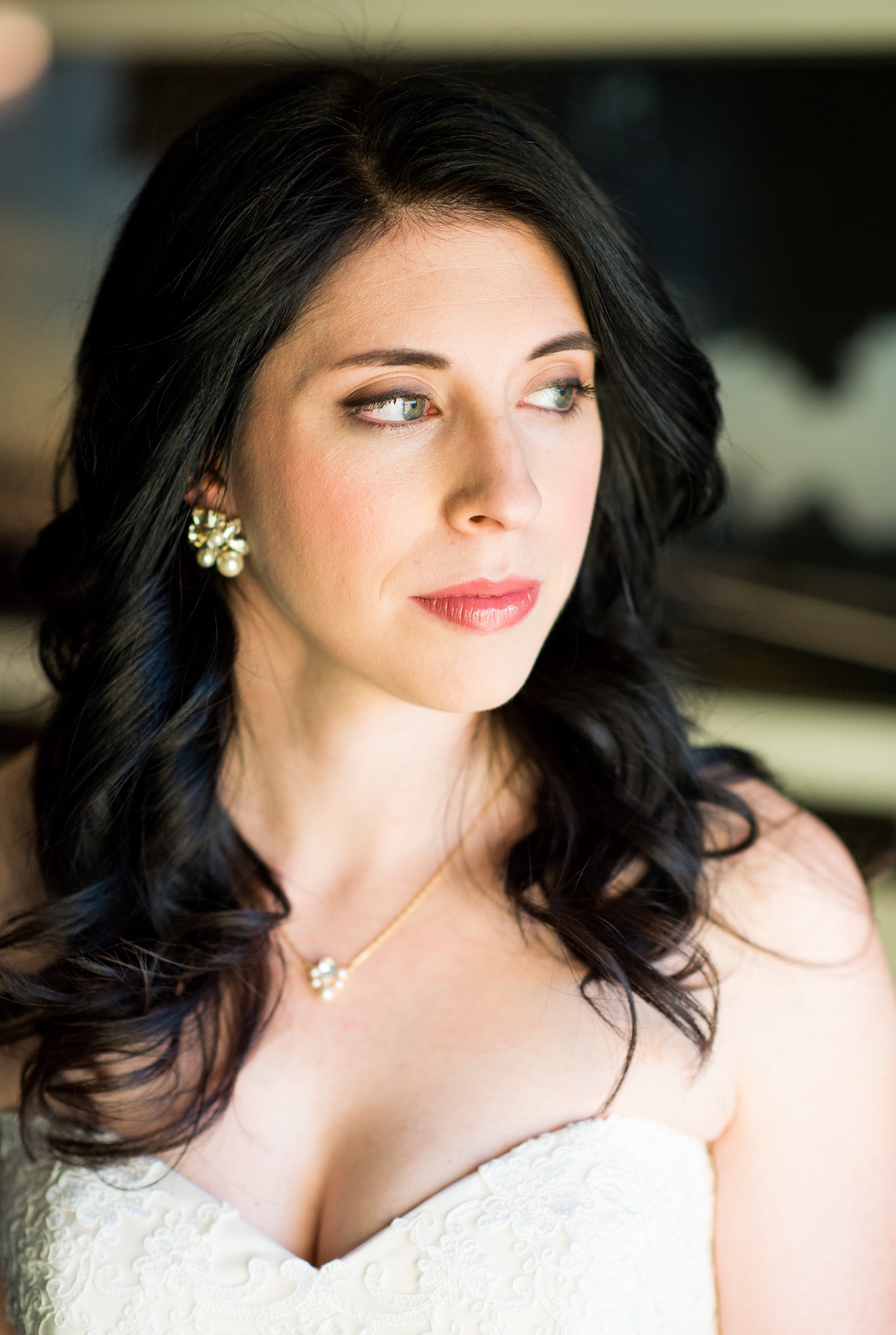 Bride with a soft, glowing natural makeup look and warm complexion, photographed in window light